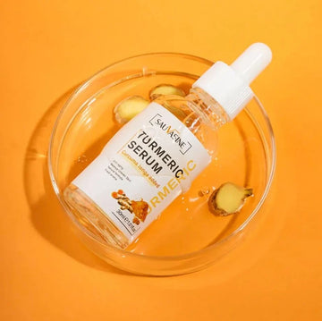 A clear dropper bottle of SAUVAGE Turmeric Serum resting inside a transparent round dish on a bright orange background, with small turmeric root pieces visible around it.